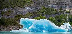 Iceberg Azul Frente a Pared Rocosa en Patagonia