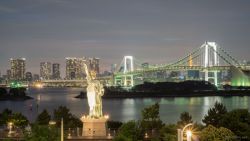 Vista nocturna de la Estatua de la Libertad y Rainbow Bridge