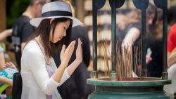 Chica Japonesa se esparce el humo para purificarse en templo Budista